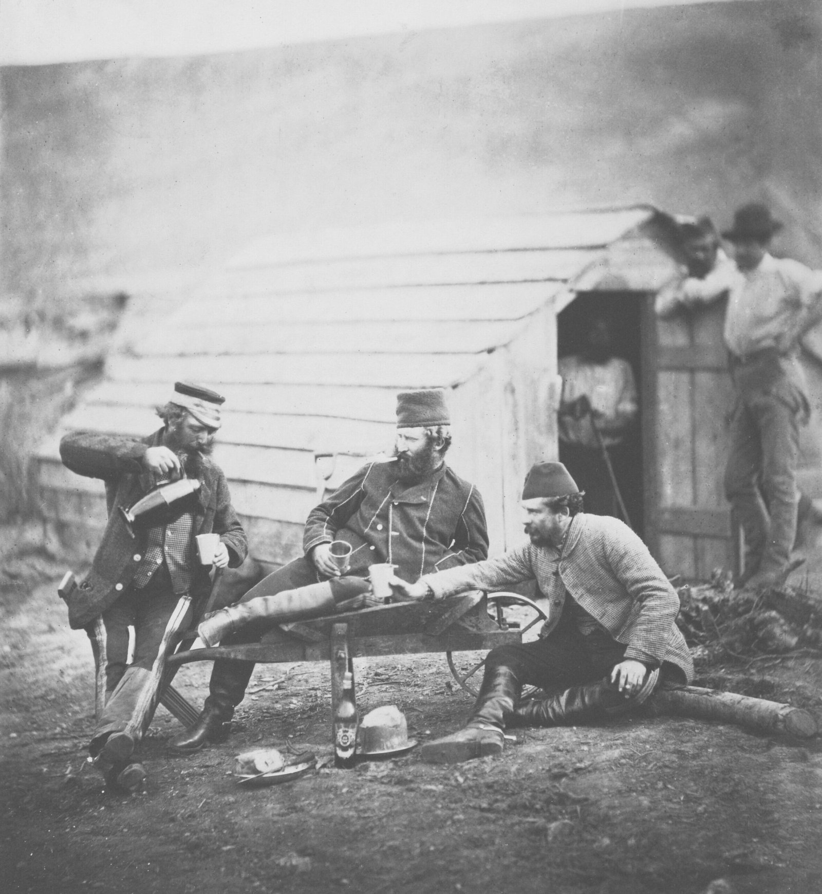 a group of men sitting around a wooden structure